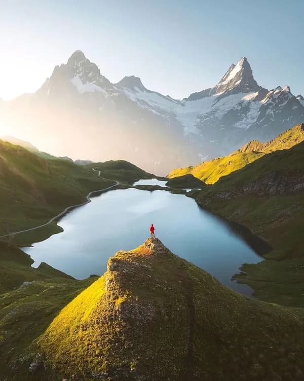 A person overlooking a mountain valley at sunrise.